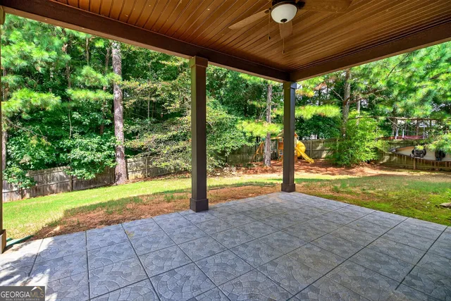 a view of swimming pool with lawn chairs next to yard