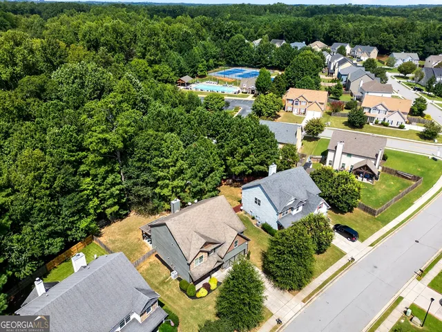 an aerial view of residential house with outdoor space and trees all around