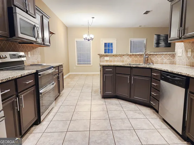 a kitchen with stainless steel appliances granite countertop a sink and cabinets