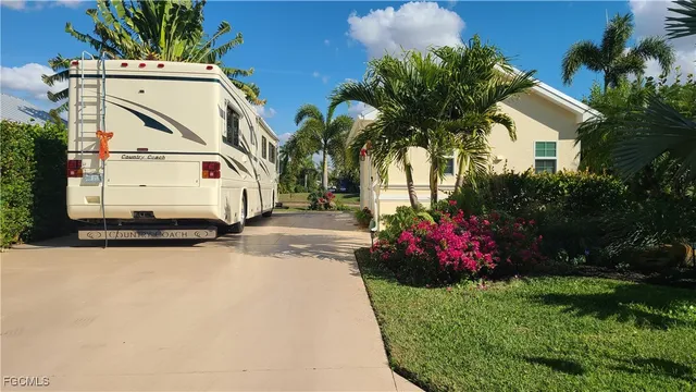 a view of a white house with a yard and potted plants