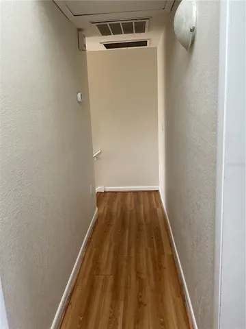 a view of a small space with wooden floor and a window