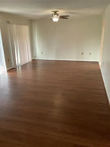 a view of a refrigerator in kitchen and an empty room