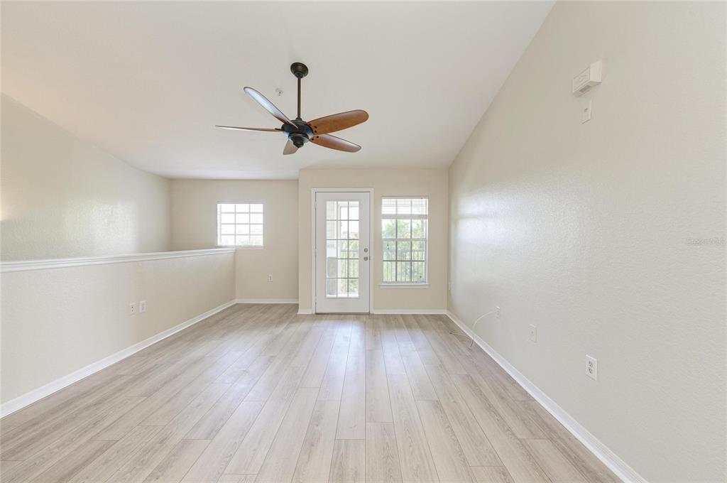 8911 Manor Loop, Unit 207 Lakewood Ranch, FL 34202 - Photo 11 of 71 a view of an empty room with a window and wooden floor
