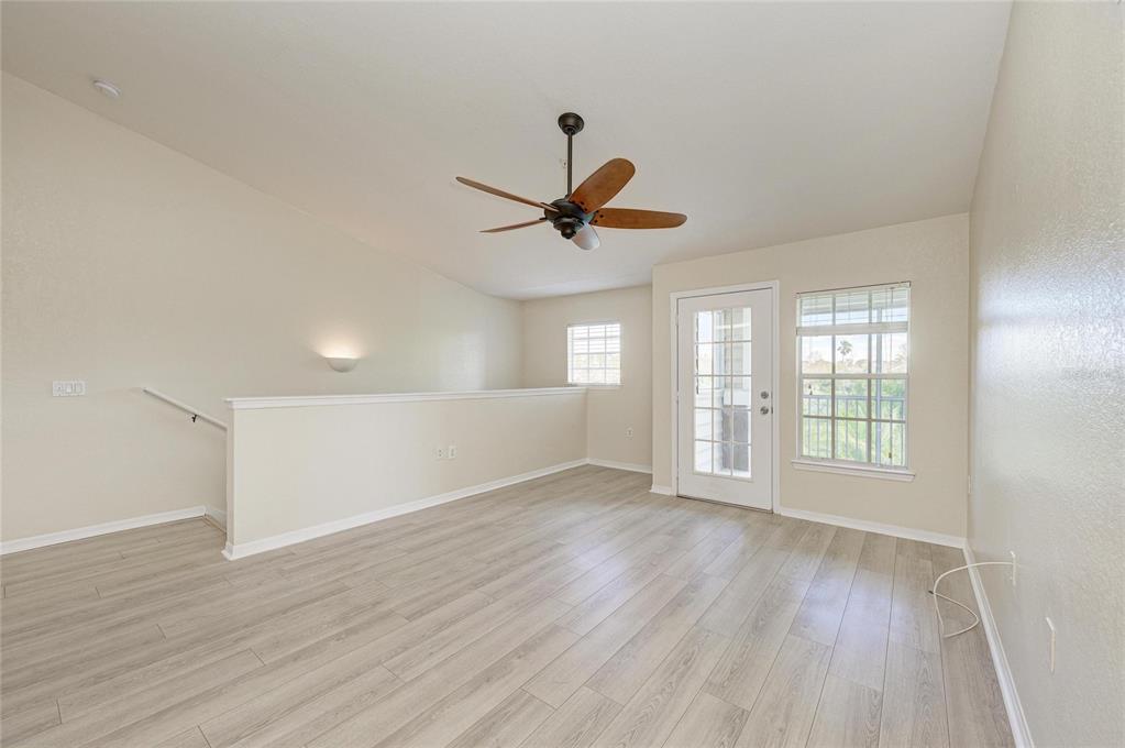 8911 Manor Loop, Unit 207 Lakewood Ranch, FL 34202 - Photo 12 of 71 an empty room with wooden floor and windows