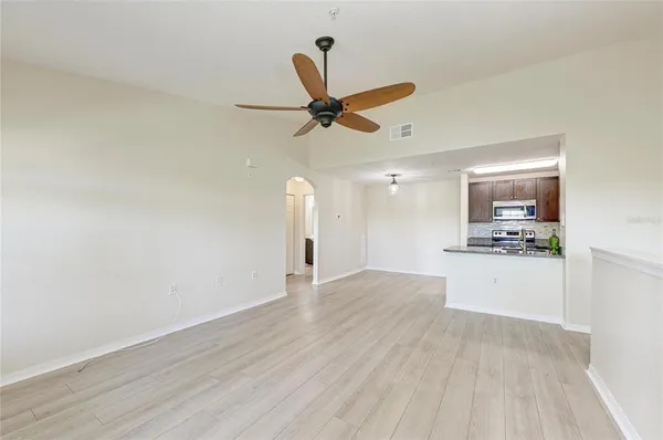 a view of a kitchen with a sink wooden floor and a living room