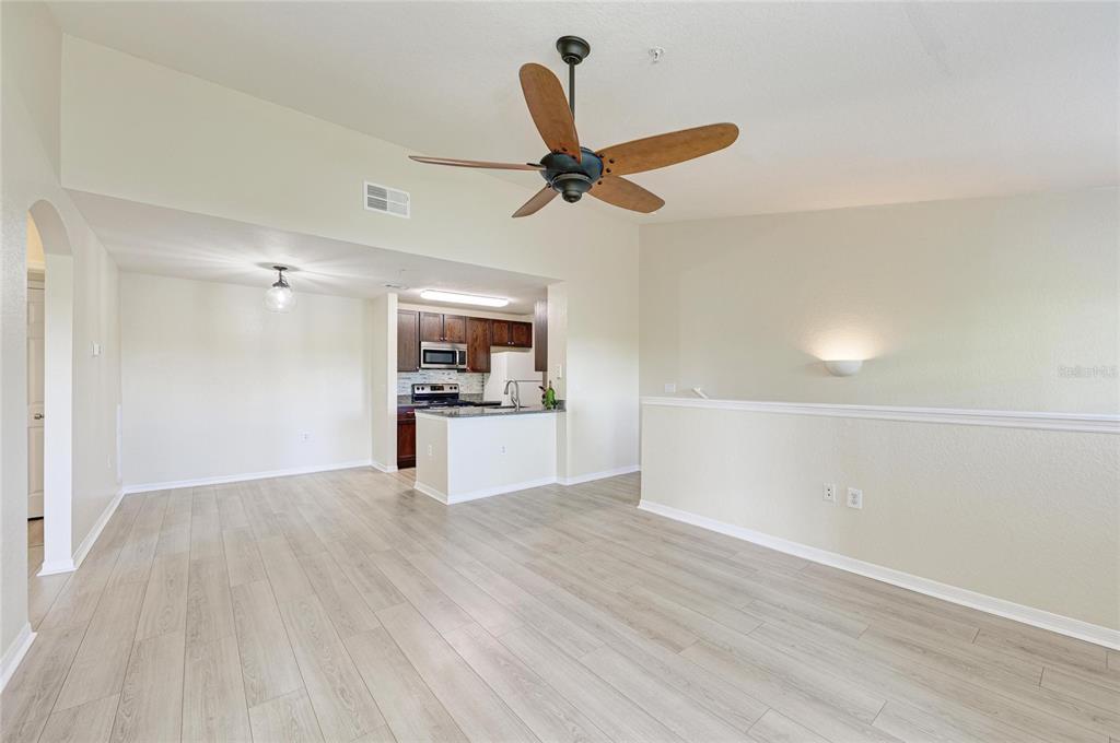 8911 Manor Loop, Unit 207 Lakewood Ranch, FL 34202 - Photo 21 of 71 a view of a kitchen with a sink wooden floor and a living room