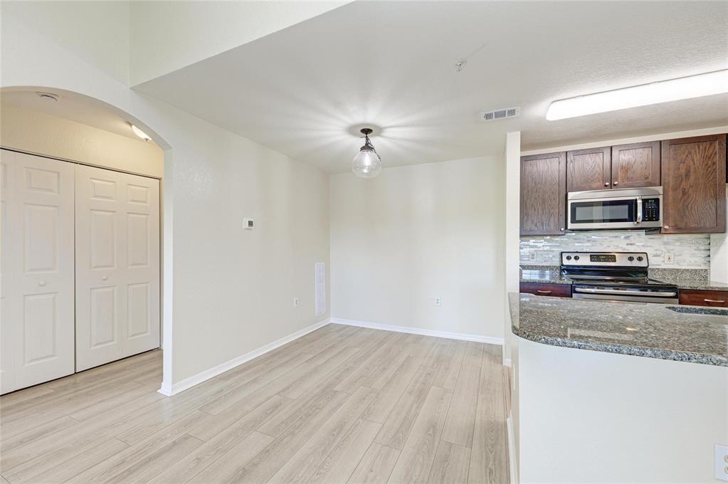 8911 Manor Loop, Unit 207 Lakewood Ranch, FL 34202 - Photo 24 of 71 a view of a kitchen with wooden floor electronic appliances and cabinets
