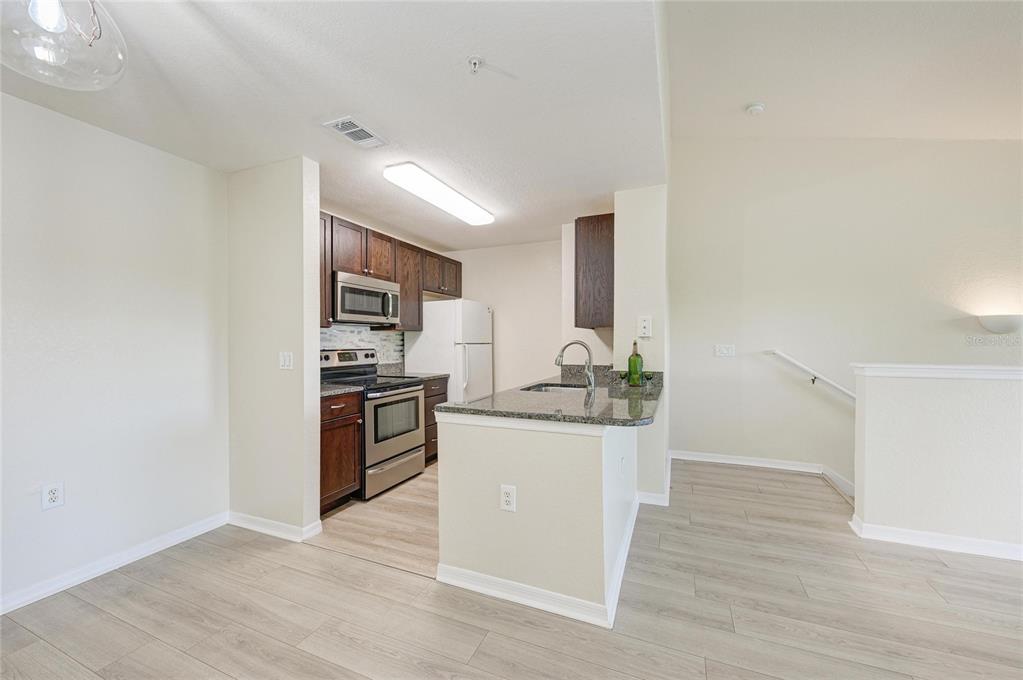 8911 Manor Loop, Unit 207 Lakewood Ranch, FL 34202 - Photo 26 of 71 a kitchen with stainless steel appliances a sink stove and refrigerator