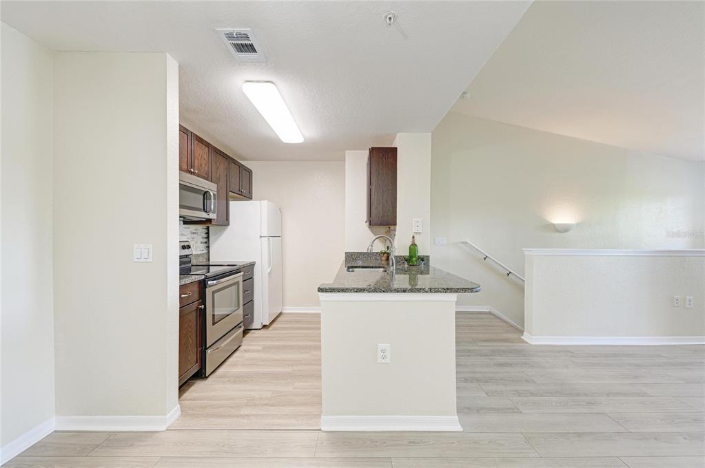 8911 Manor Loop, Unit 207 Lakewood Ranch, FL 34202 - Photo 27 of 71 a kitchen with stainless steel appliances a refrigerator and a stove top oven