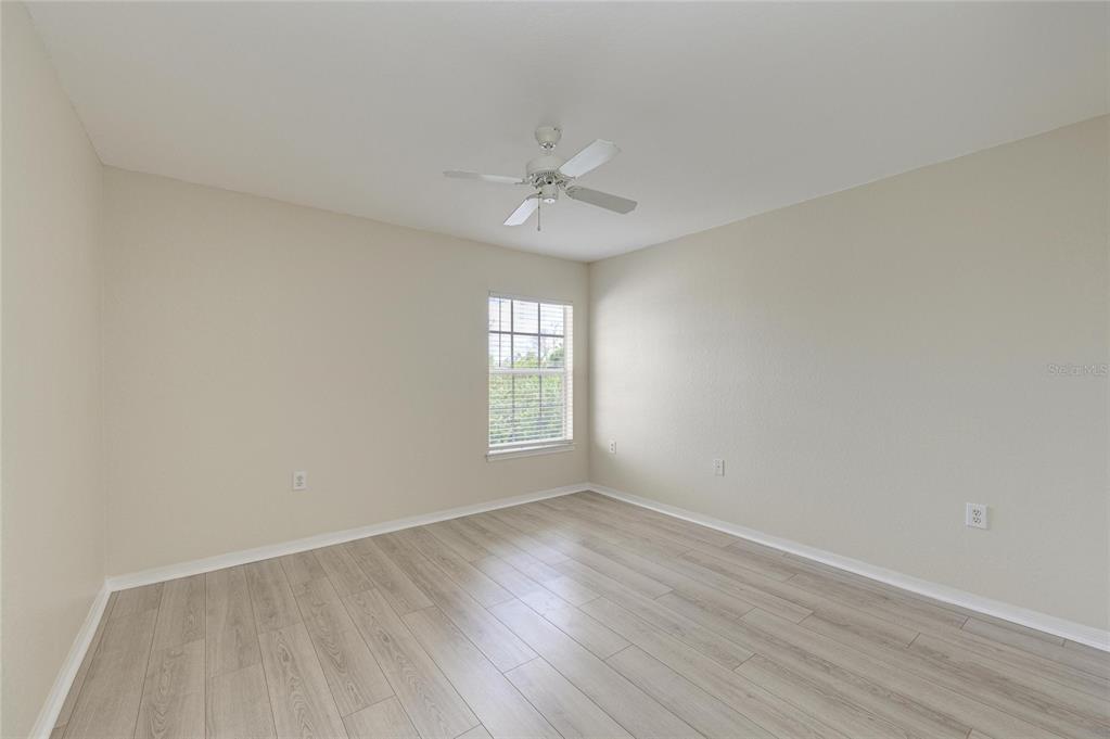 8911 Manor Loop, Unit 207 Lakewood Ranch, FL 34202 - Photo 32 of 71 an empty room with wooden floor ceiling fan and windows