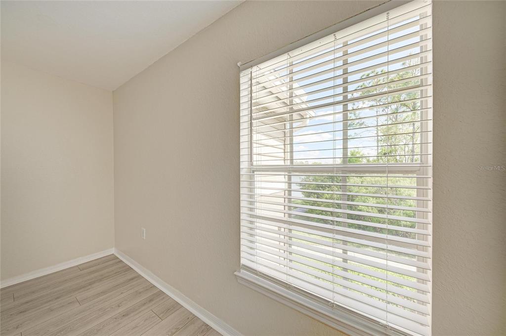 8911 Manor Loop, Unit 207 Lakewood Ranch, FL 34202 - Photo 37 of 71 a view of an empty room with wooden floor and a window