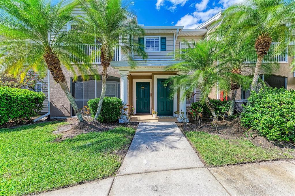 8911 Manor Loop, Unit 207 Lakewood Ranch, FL 34202 - Photo 7 of 71 a front view of a house with a yard and potted plants