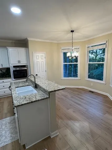 a kitchen with stainless steel appliances granite countertop a stove a sink and a wooden floors