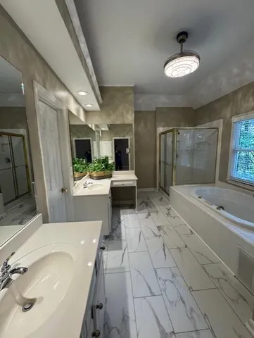 a spacious bathroom with a tub sink and mirror