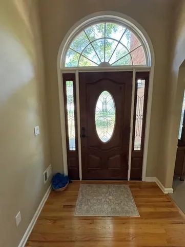 an empty room with wooden floor and mirror