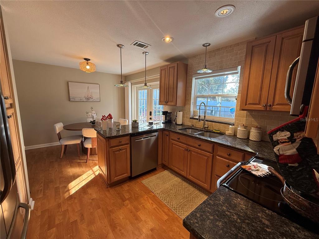 3066 19th Place Southwest Largo, FL 33774 - Photo 9 of 18 a kitchen with a sink stove and cabinets