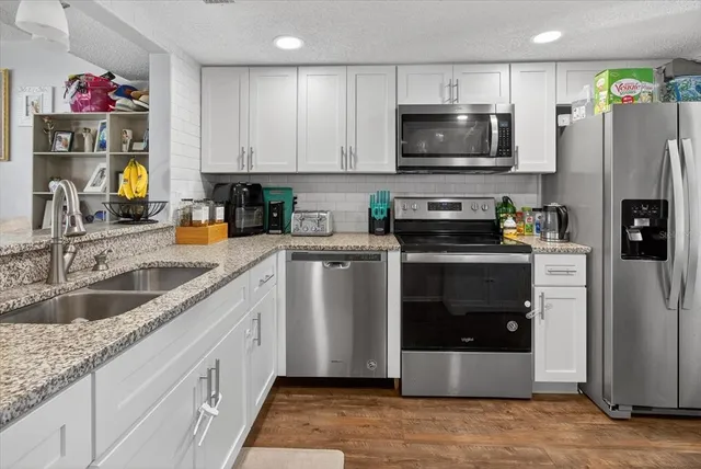 a kitchen with stainless steel appliances a stove a microwave and a refrigerator
