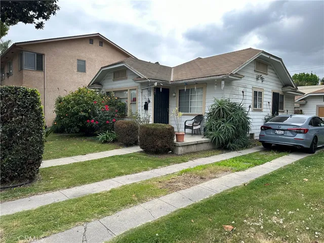 a front view of a house with a garden and plants