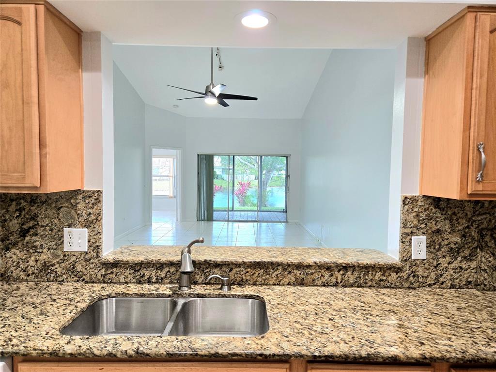 5912 Northwest 93rd Terrace Tamarac, FL 33321 - Photo 11 of 29 a bathroom with a granite countertop sink a mirror and a window