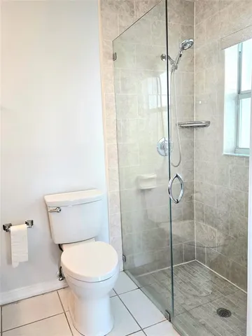 a bathroom with a granite countertop toilet and a sink
