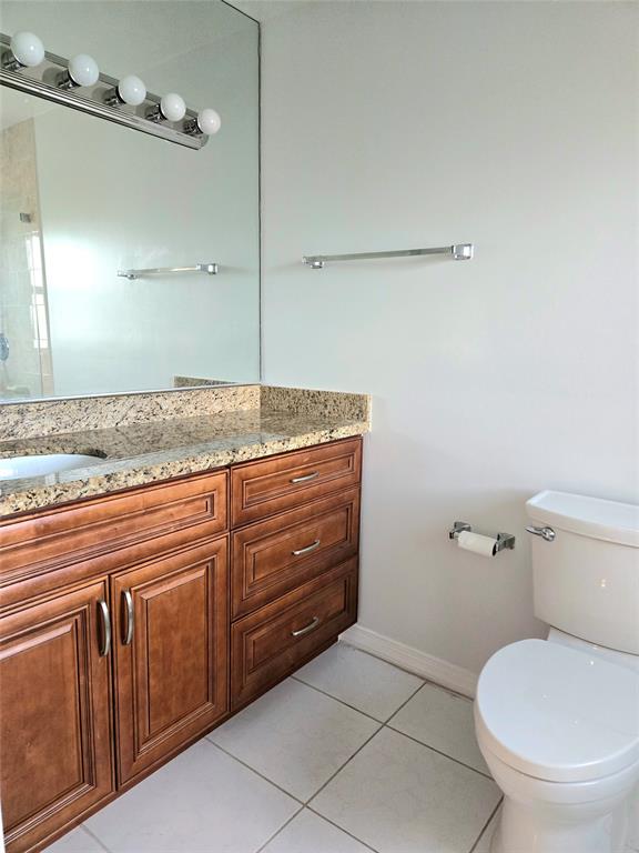 5912 Northwest 93rd Terrace Tamarac, FL 33321 - Photo 26 of 29 a bathroom with a granite countertop toilet and a sink