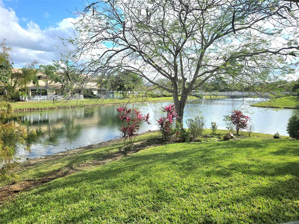 5912 Northwest 93rd Terrace Tamarac, FL 33321 - Photo 27 of 29 a view of a lake with a yard and large trees