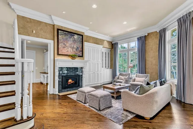 a living room with furniture large window and wooden floor