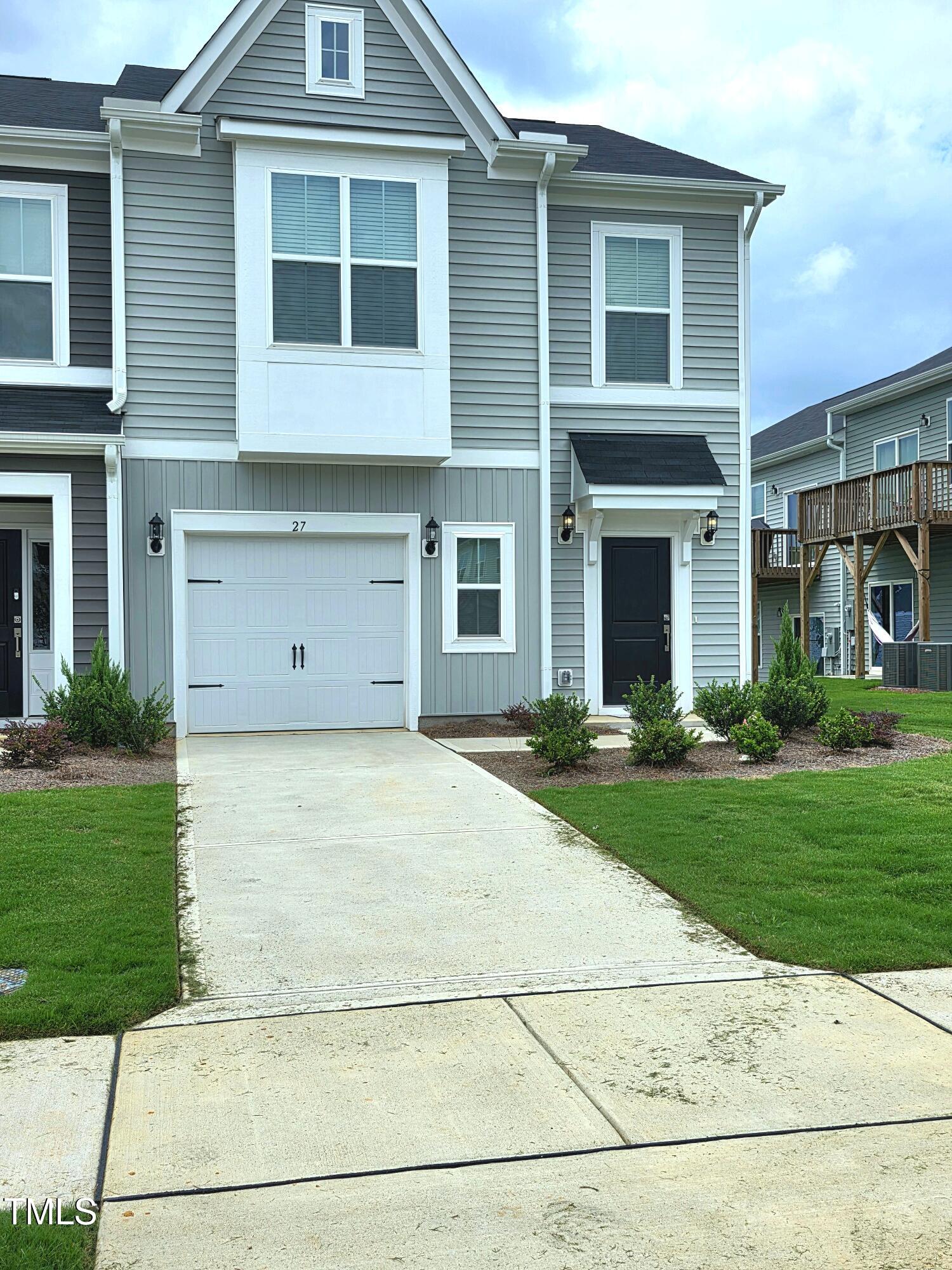 a view of a house with garage and yard