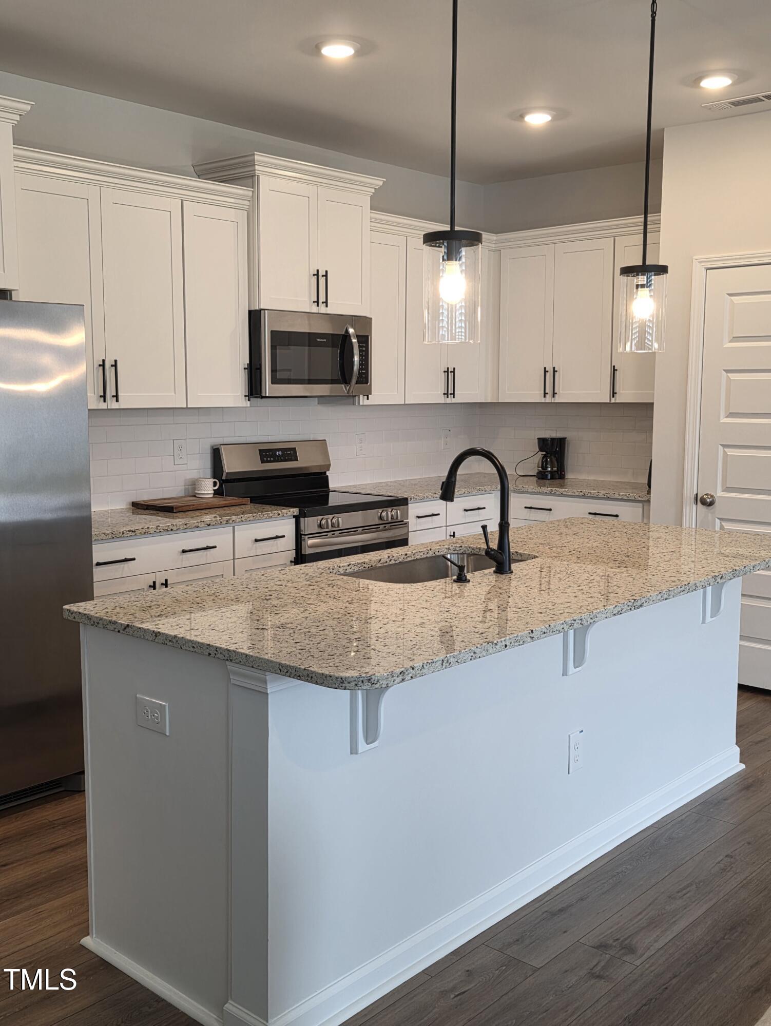 27 Nettle Lane Clayton, NC 27520 - Photo 13 of 37 a kitchen with granite countertop a sink a counter top space appliances and cabinets
