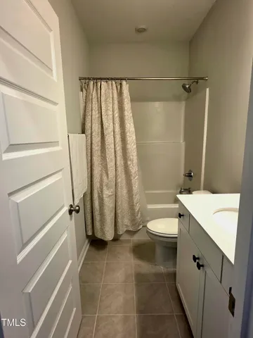 a backyard of a house with table and chairs and potted plants