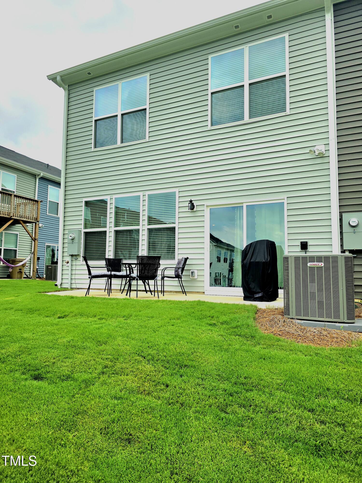 27 Nettle Lane Clayton, NC 27520 - Photo 36 of 37 a backyard of a house with table and chairs and potted plants