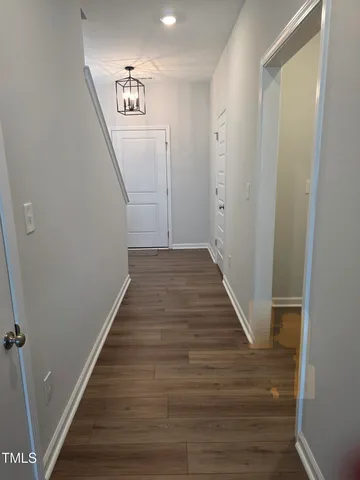a view of a hallway with wooden floor and entryway
