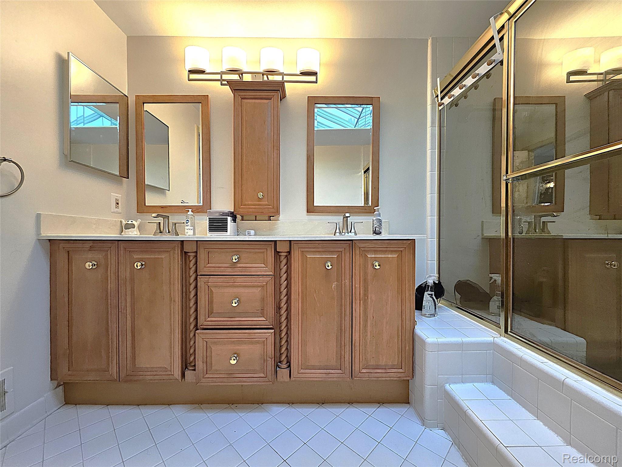 1114 Chaffer Drive Rochester, MI 48306 - Photo 42 of 50 Double vanity featuring wood-finish cabinetry, a light-toned countertop, and dual sinks with chrome faucets