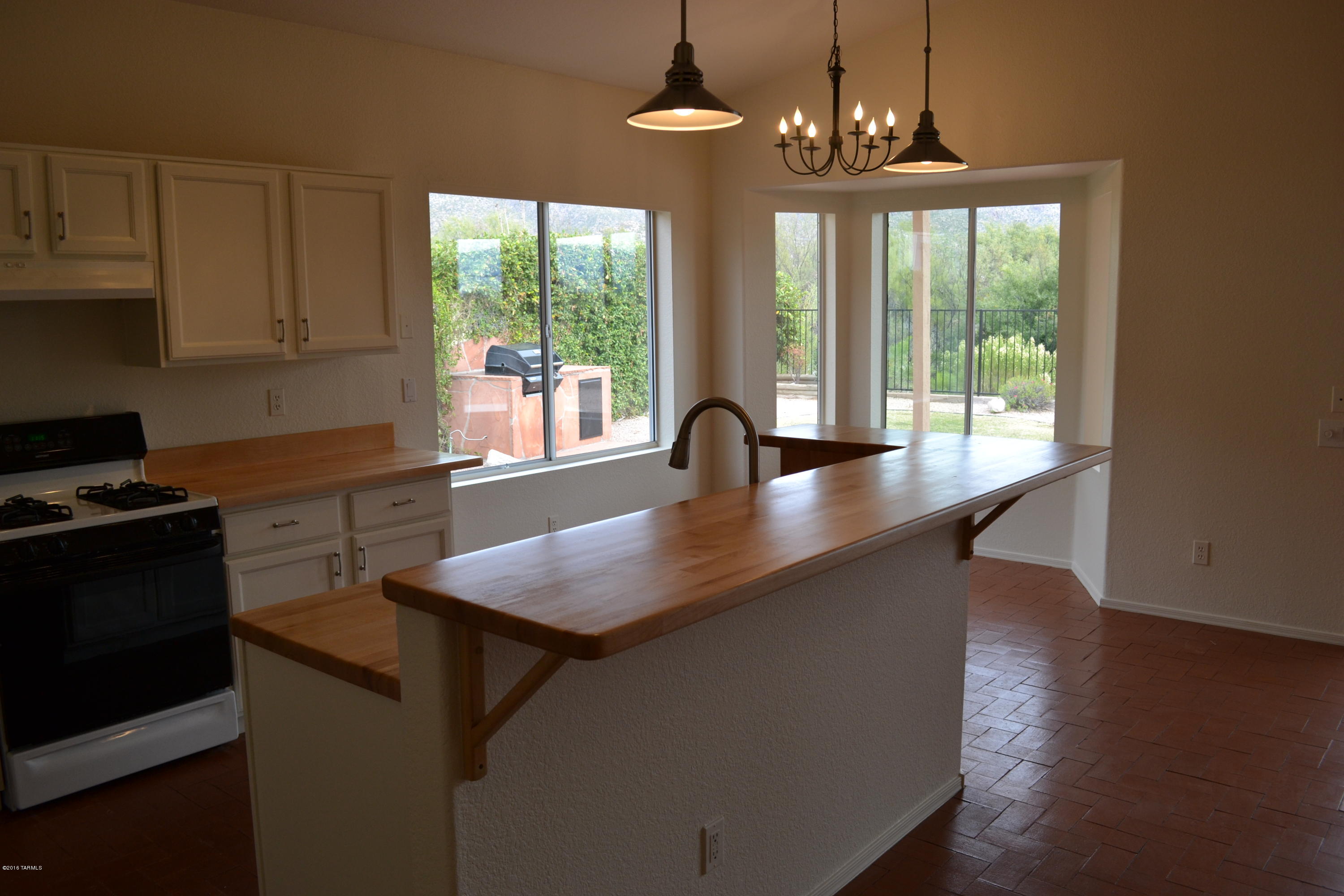 5640 North Cherokee Ridge Road Tucson, AZ 85750 - Photo 9 of 39 a kitchen with stainless steel appliances granite countertop a stove a sink a window and dining table