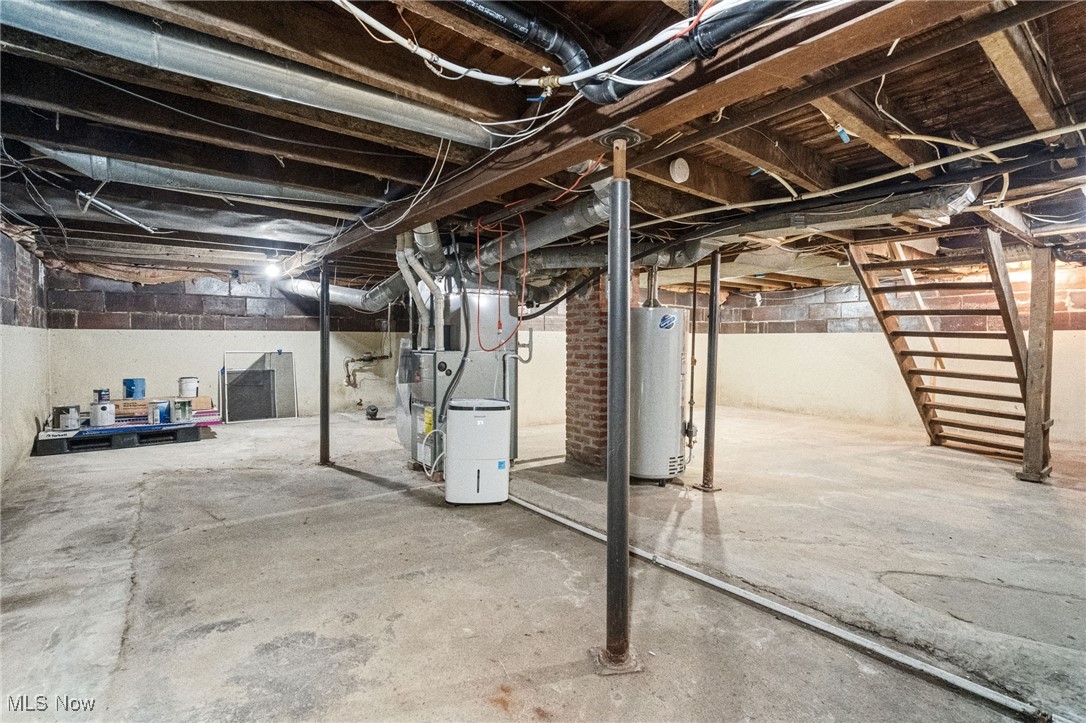 21 South 3rd Street Rittman, OH 44270 - Photo 23 of 39 Unfinished basement featuring water heater, heating unit, and stairway