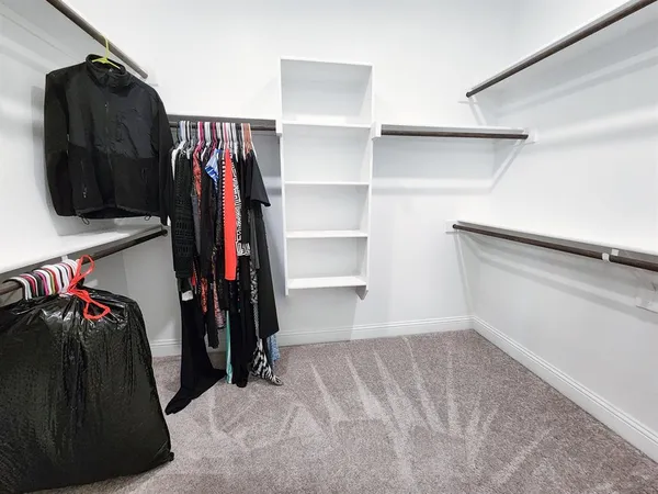 a view of walk in closet with clothes and shoes