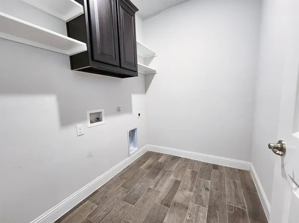 a view of a room with wooden floor and cabinets