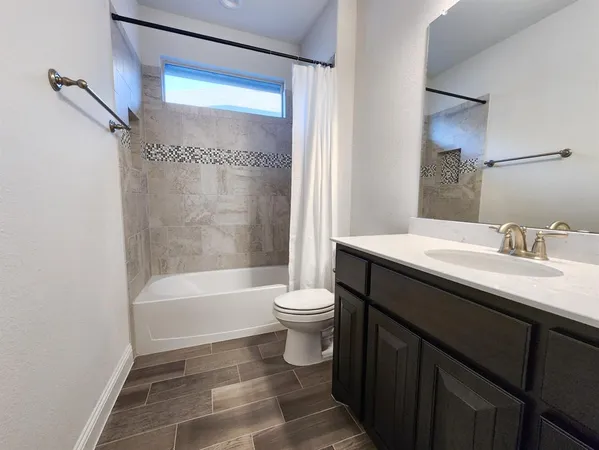 a bathroom with a double vanity sink toilet and shower