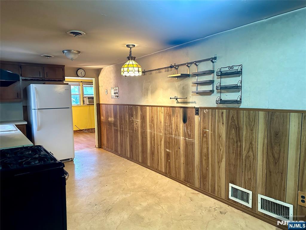 a view of kitchen with furniture and a refrigerator