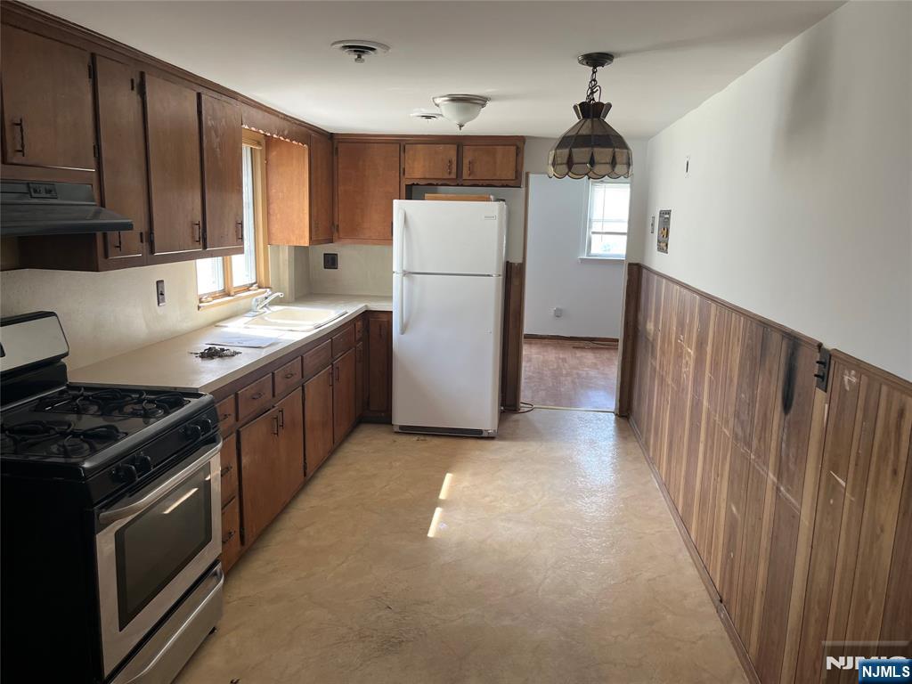 70 Orchard Street Garfield, NJ 07026 - Photo 12 of 17 a kitchen with a refrigerator a stove top oven and cabinets
