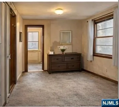 an empty room with a window and a wardrobe