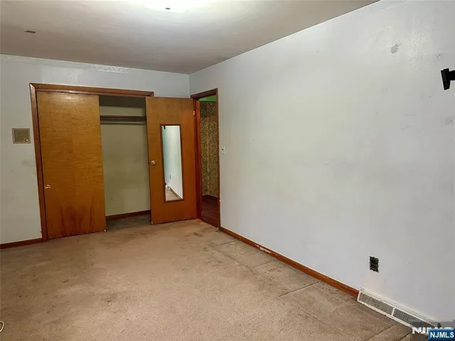 an empty room with closet and entrance