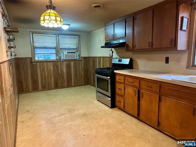 a kitchen with cabinets and wooden floor