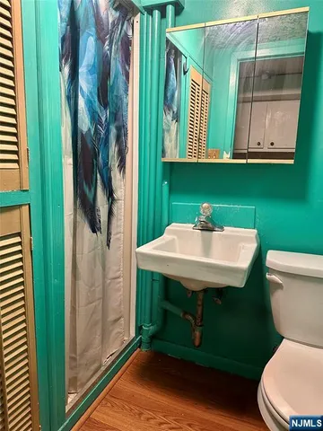 a bathroom with a toilet a sink and a mirror