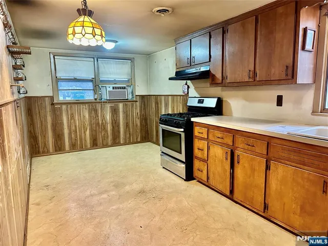 a kitchen with stainless steel appliances granite countertop a stove top oven a sink dishwasher and a microwave oven on the blue kitchen countertops