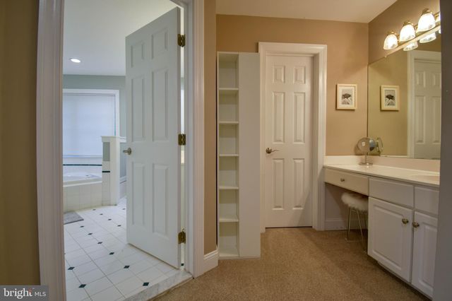 a spacious bathroom with a tub sink and mirror