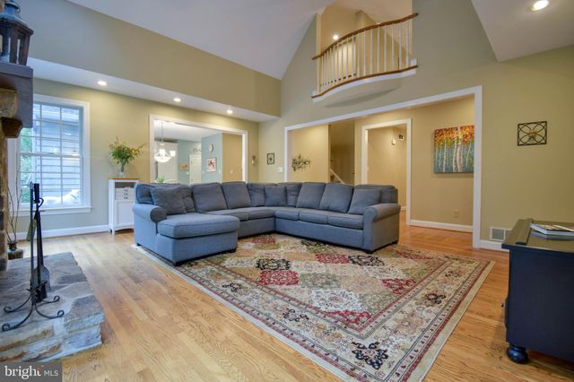 a living room with a couch and a dining table with wooden floor