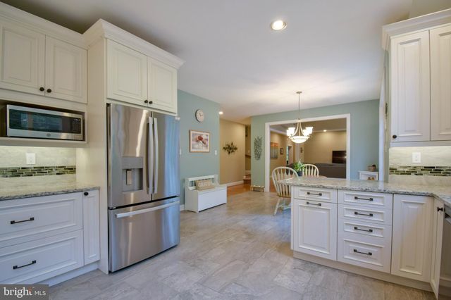 a kitchen with granite countertop cabinets appliances and a counter space
