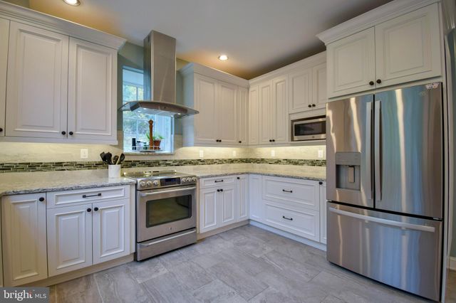 a kitchen with cabinets stainless steel appliances and a counter space