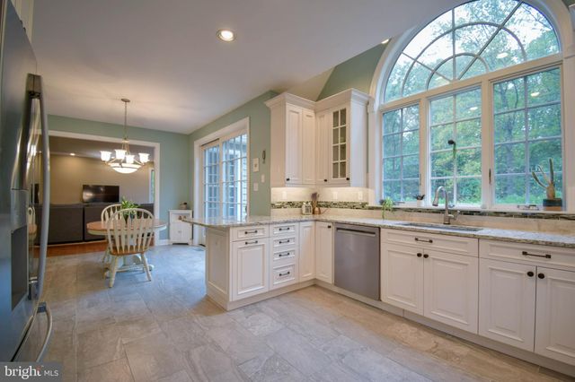 a large white kitchen with a large window